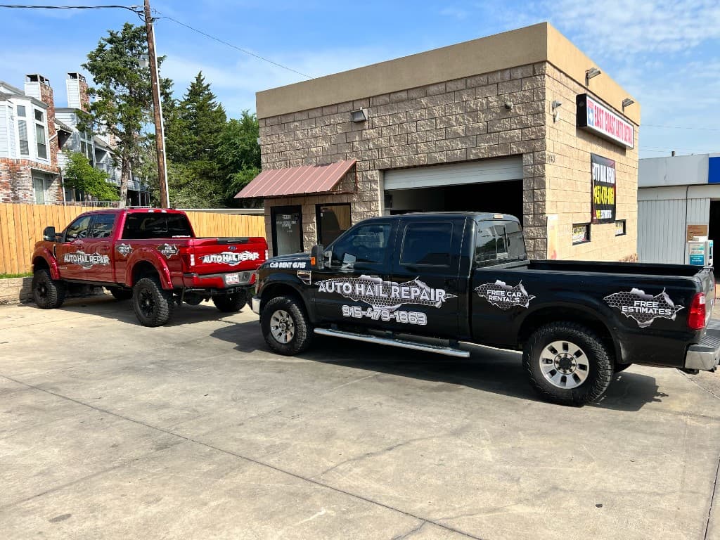 C & D Dent Guys red and black branded trucks parked outside the repair shop