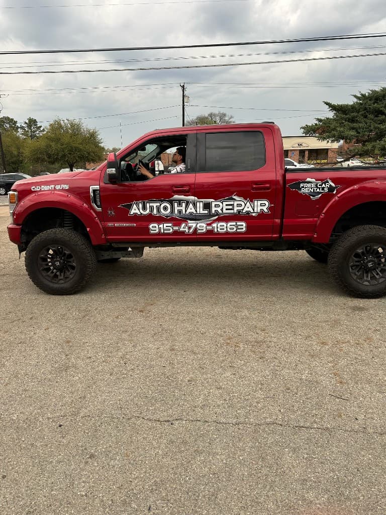 C & D Dent Guys red Ford Super Duty with Auto Hail Repair branding — driver side view