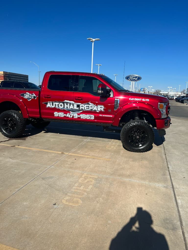 C & D Dent Guys red truck at Ford dealership with Auto Hail Repair branding